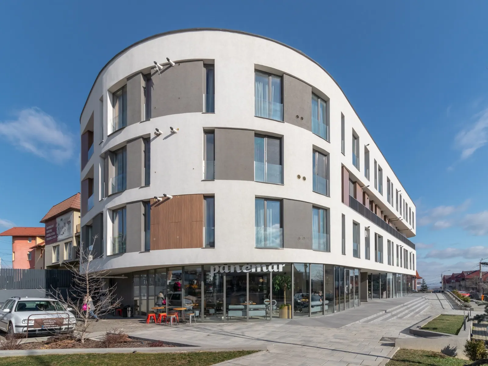 Fagului 88 — curved white residential building on a street corner